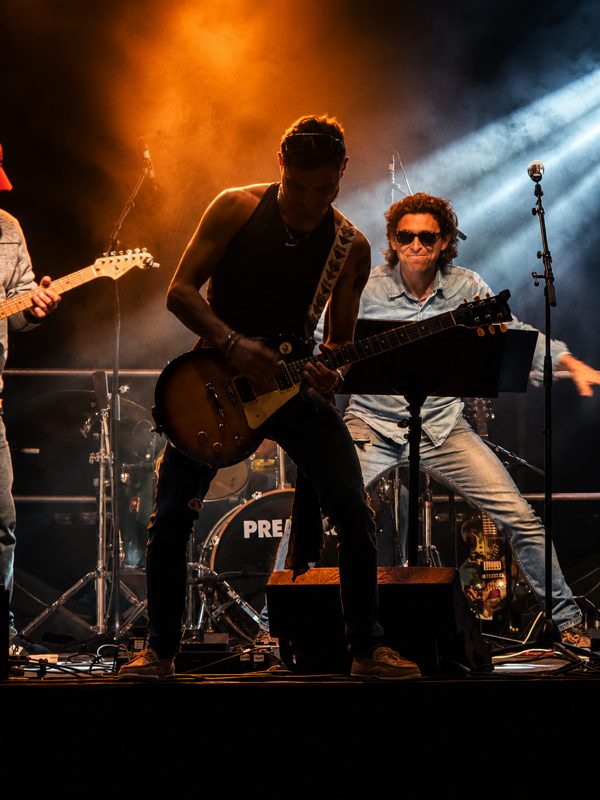 Alambic Brothers — Guitaristes sous les lumières orange et bleues