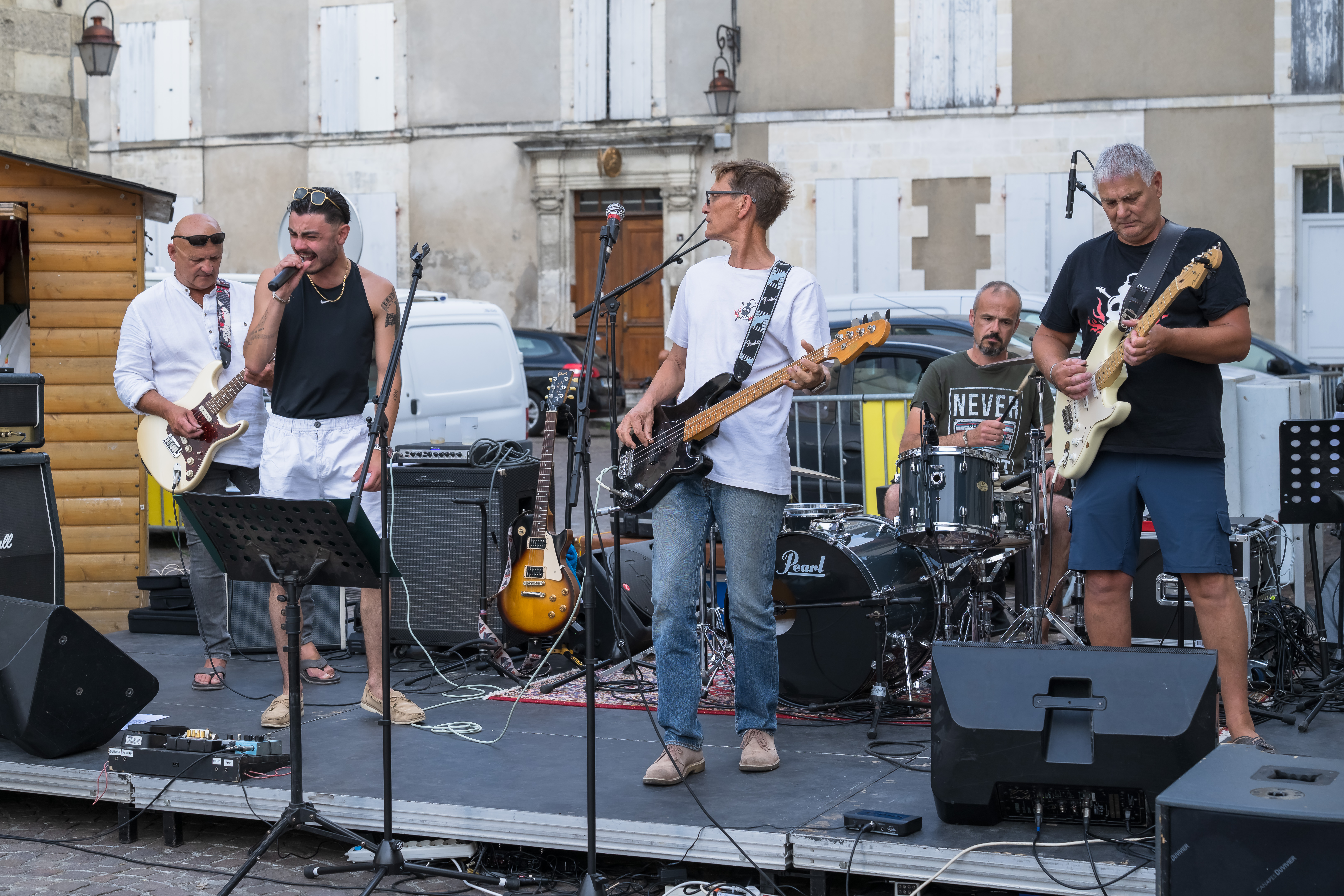 Les cinq musiciens d’Alambic Brothers jouent sur une scène en extérieur.